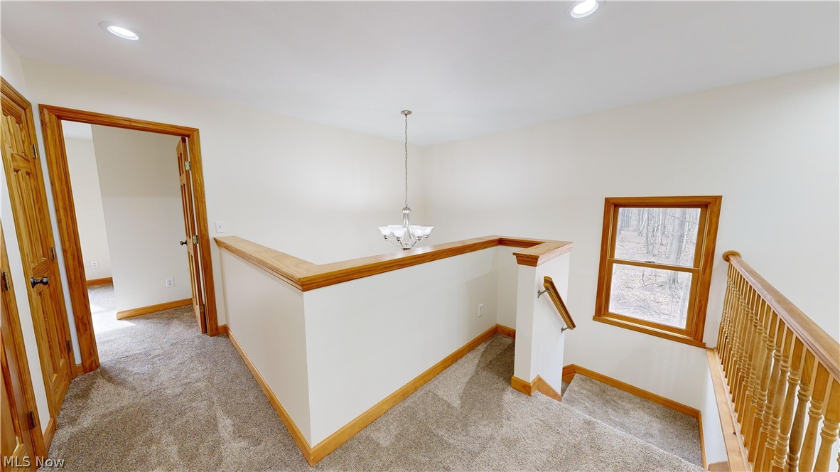 15548 Trask Road Thompson, OH 44086 - Photo 18 of 31 Corridor featuring light carpet and an inviting chandelier