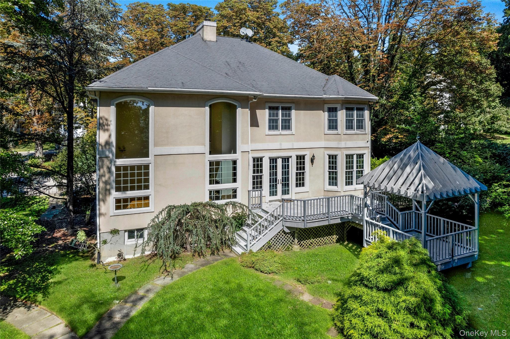 25 Riverview Road Irvington, NY 10533 - Photo 2 of 41 Stucco exterior with multi-pane windows, elevated deck, and a gazebo