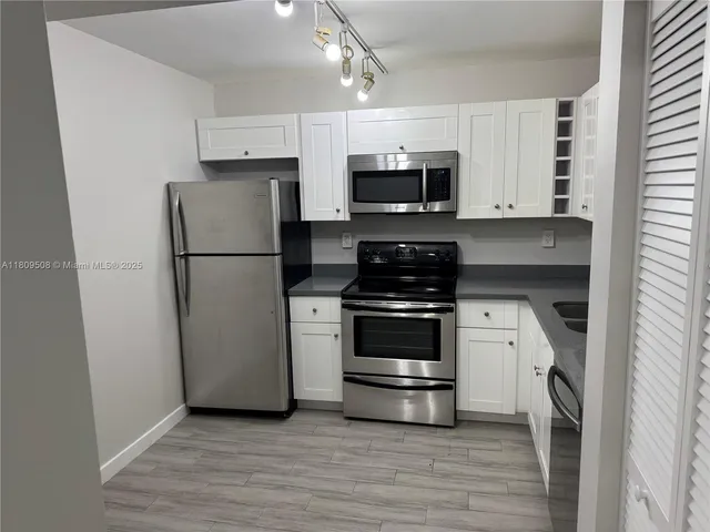 a kitchen with stainless steel appliances a refrigerator stove and microwave