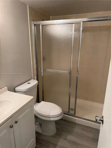 a white toilet sitting next to a shower
