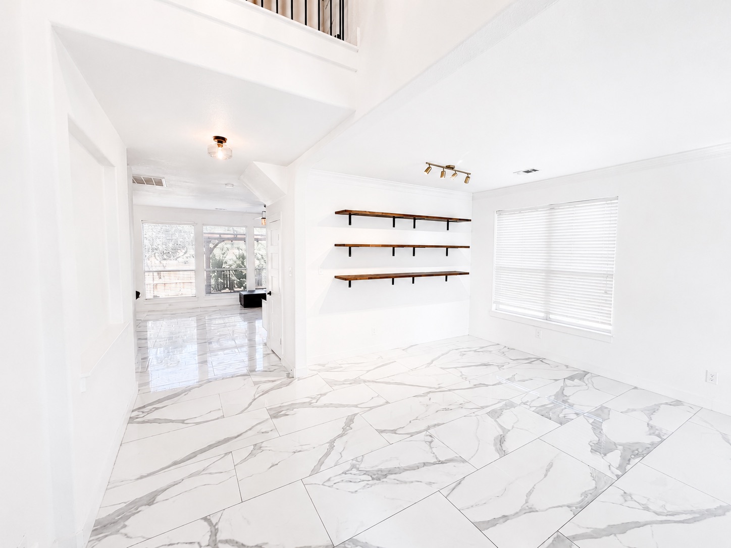 1610 Juniper Ridge Loop Cedar Park, TX 78613 - Photo 9 of 28 Gleaming marble-patterned tile flooring spans this bright dining area featuring minimalist floating shelves.