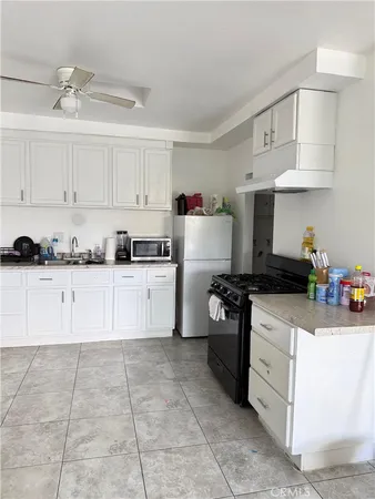 a kitchen with cabinets a sink and white stainless steel appliances