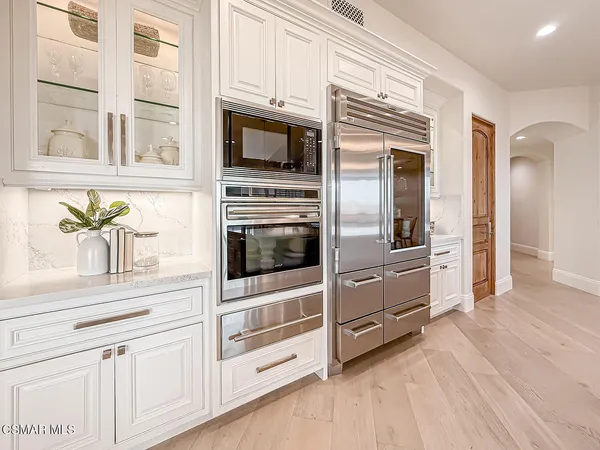 a spacious bedroom with a large bed and a chandelier
