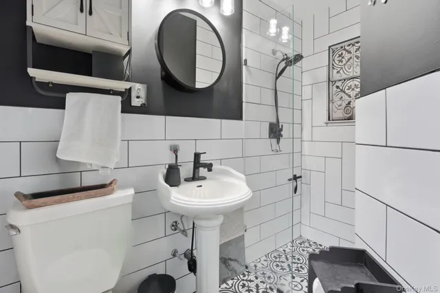 a bathroom with a sink toilet and a mirror