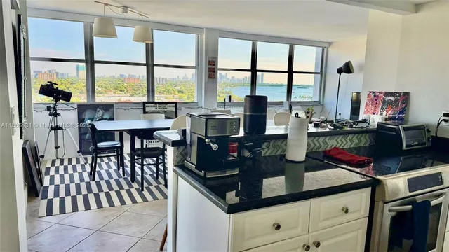 a kitchen with stainless steel appliances kitchen island granite countertop a table and chairs a barbeque with wooden floor