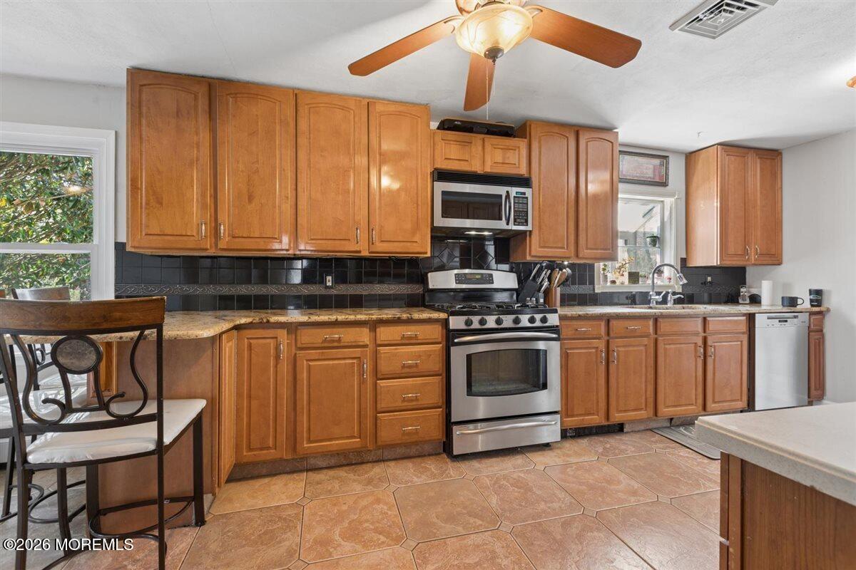 436 Cook Road Jackson, NJ 08527 - Photo 10 of 44 a kitchen with stainless steel appliances granite countertop a stove a sink and a microwave