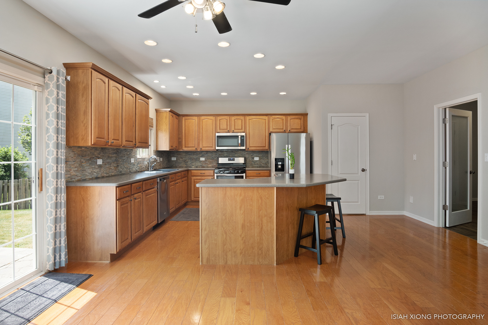 3255 Marbill Farm Road Montgomery, IL 60538 - Photo 4 of 22 a kitchen with stainless steel appliances granite countertop a refrigerator a sink dishwasher a stove and a dining table with wooden floor