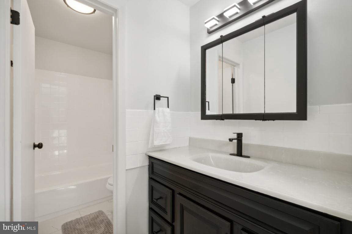 2400 Kilpatrick Place Dumfries, VA 22026 - Photo 14 of 20 a bathroom with a sink a mirror and a shower
