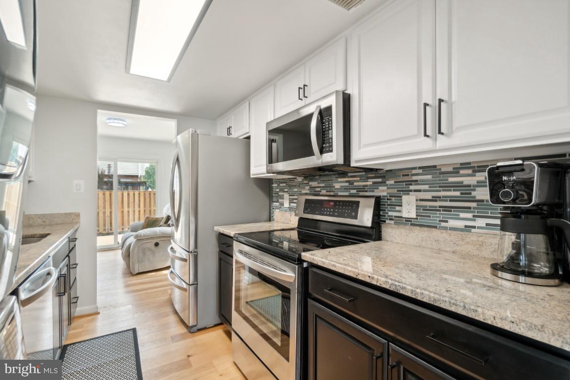 2400 Kilpatrick Place Dumfries, VA 22026 - Photo 9 of 20 a kitchen with stainless steel appliances granite countertop a stove a sink and a microwave