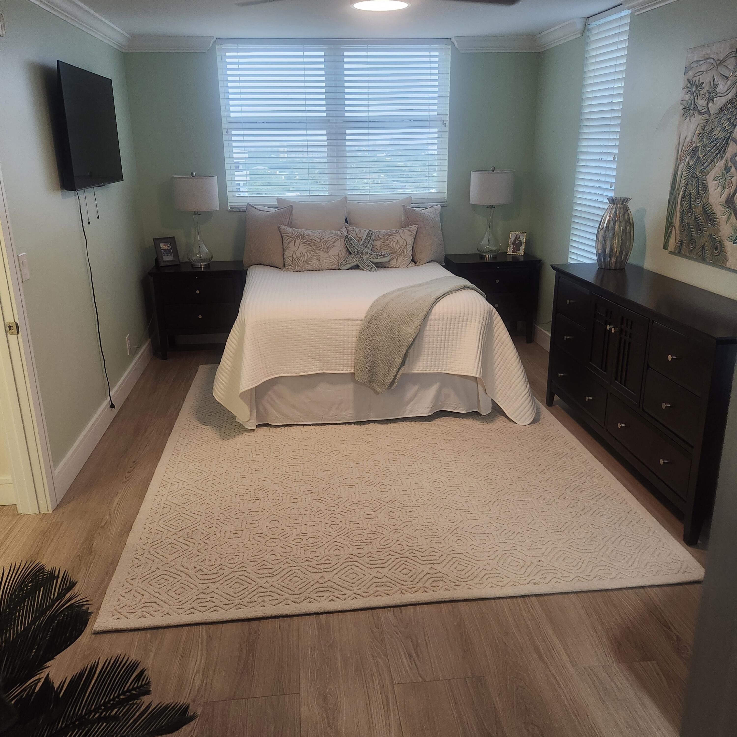 1505 North Riverside Drive, Unit 1108 Pompano Beach, FL 33062 - Photo 13 of 16 a bedroom with a bed and wooden floor