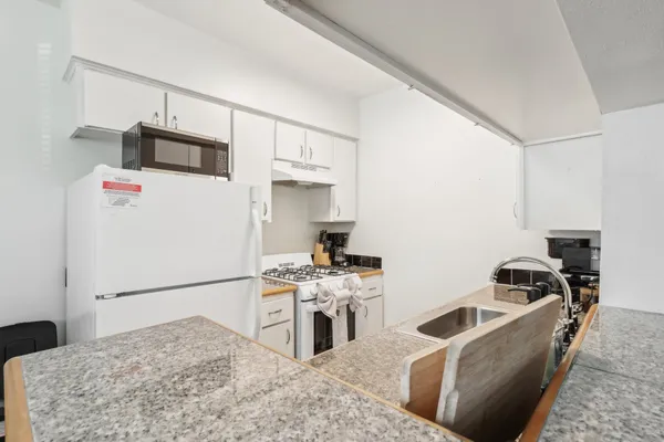 a kitchen with stainless steel appliances granite countertop a sink stove and refrigerator