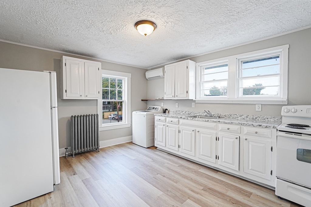 72 Main Street Pepperell, MA 01463 - Photo 4 of 26 a kitchen with granite countertop white cabinets and wooden floor