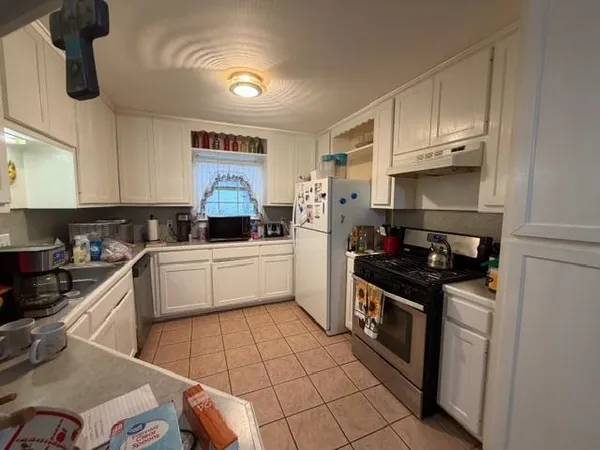 a kitchen with stainless steel appliances a stove a sink and a refrigerator