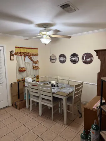 a view of a dining room with furniture and a chandelier fan