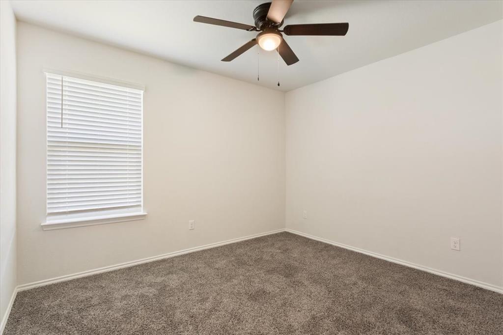 6317 Elephant Butte Drive Waco, TX 76708 - Photo 29 of 39 Neutral-toned room featuring a window with white blinds, a ceiling fan with integrated lighting, and plush carpet flooring