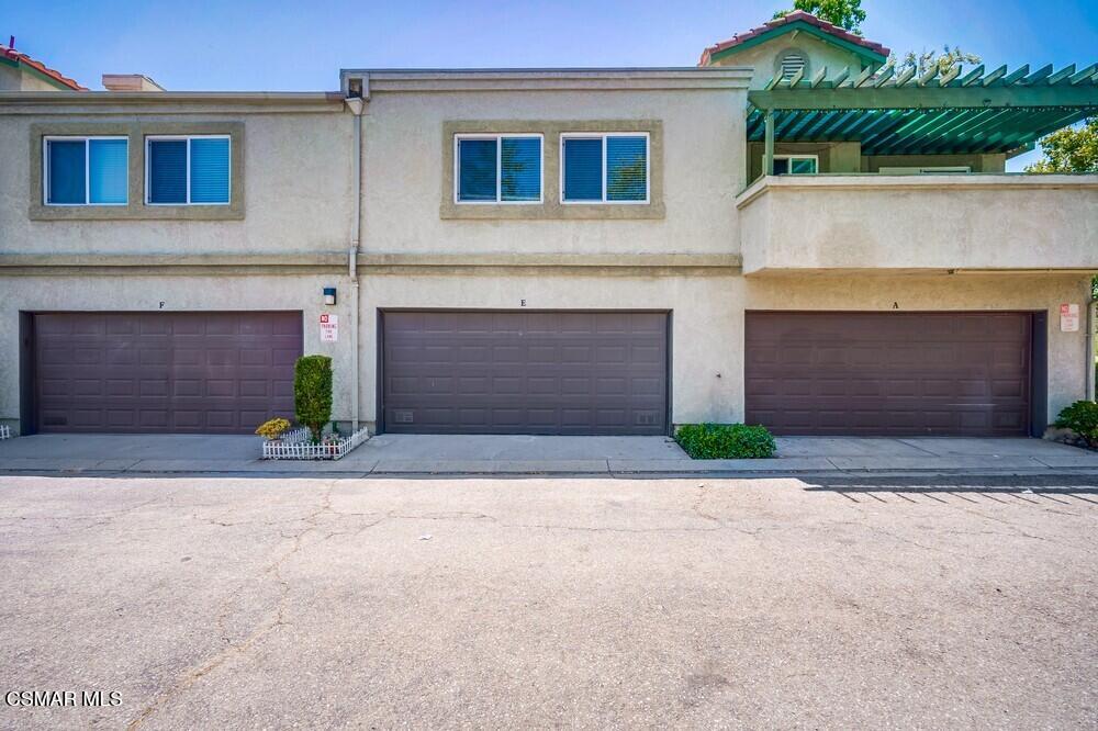 8328 Spring Desert Place, Unit E Rancho Cucamonga, CA 91730 - Photo 21 of 27 a front view of a house with a yard and a garage