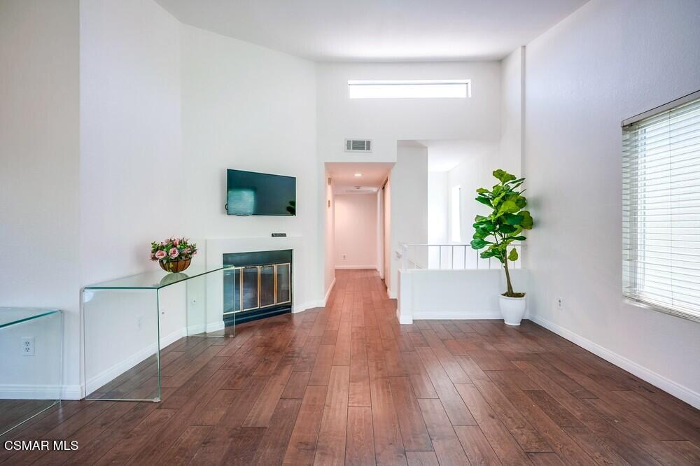 8328 Spring Desert Place, Unit E Rancho Cucamonga, CA 91730 - Photo 8 of 27 a hallway with wooden floor and a potted plant