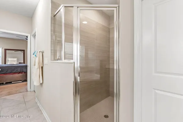 a bedroom with a large bed a flat screen tv and a large window