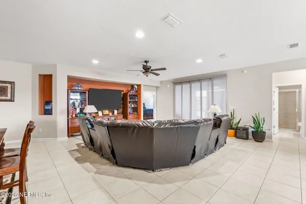 a kitchen with stainless steel appliances kitchen island granite countertop a dining table chairs refrigerator and cabinets