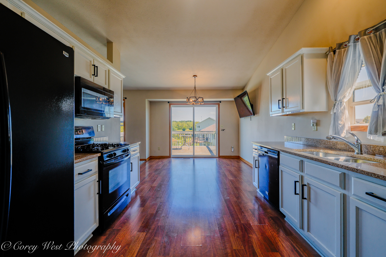 8453 Crooked Bend Road Machesney Park, IL 61115 - Photo 10 of 27 a kitchen with granite countertop wooden floors a stove and a refrigerator