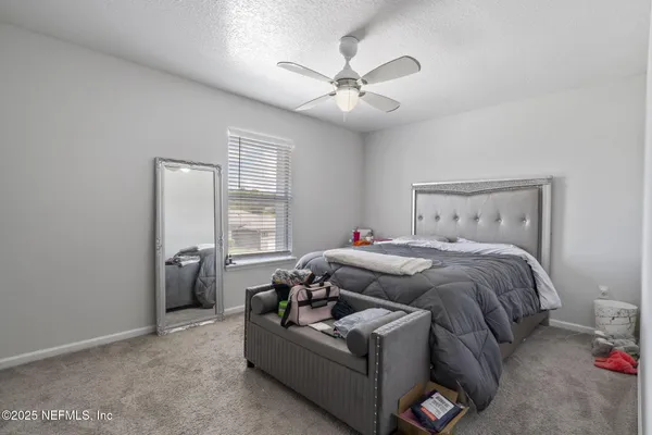 a bedroom with a bed couch and window