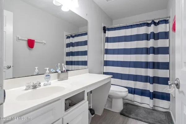 a bathroom with a sink a toilet a shower and a mirror