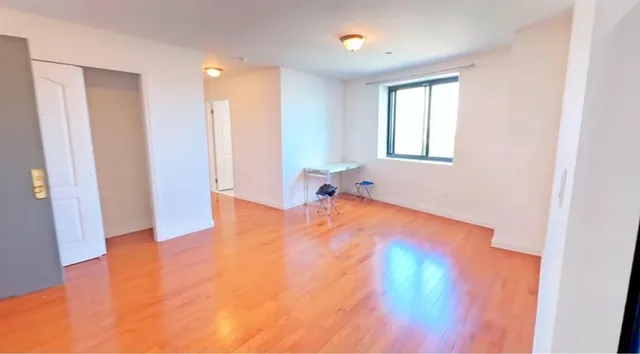 a view of empty room with wooden floor