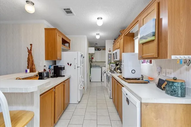 a kitchen with stainless steel appliances kitchen island granite countertop a sink stove and refrigerator