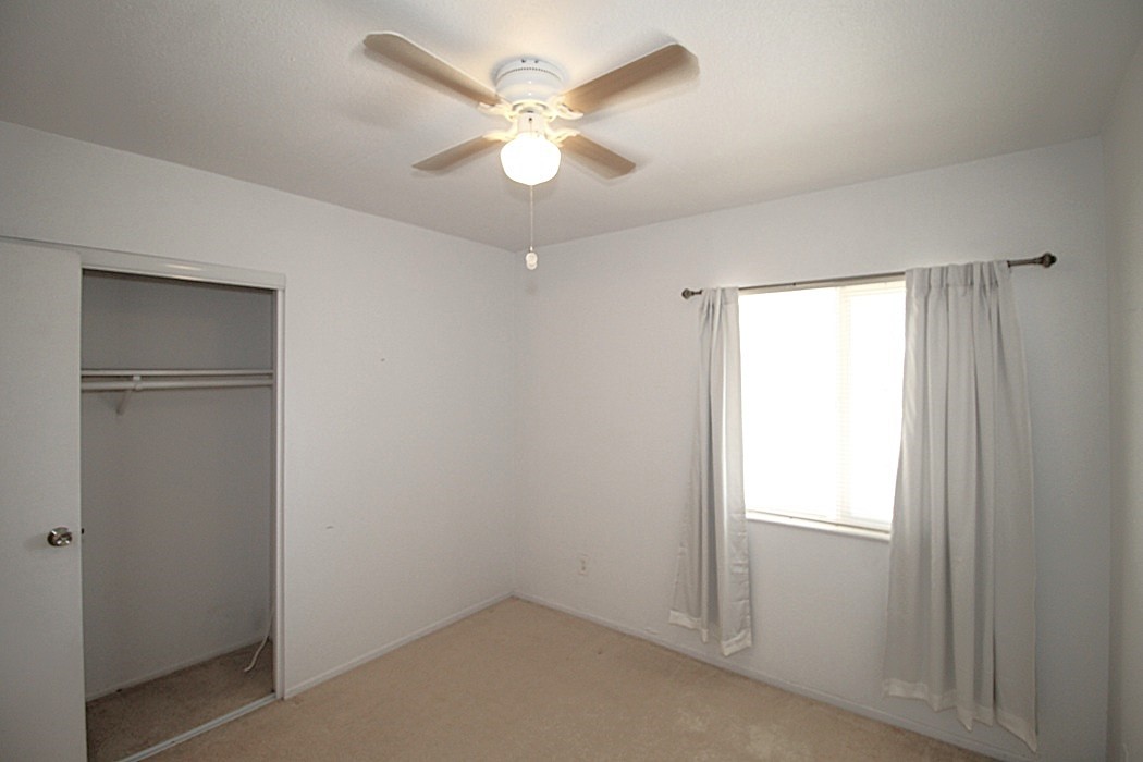 308 Muir Street Barstow, CA 92311 - Photo 12 of 27 an empty room with closet and a ceiling fan