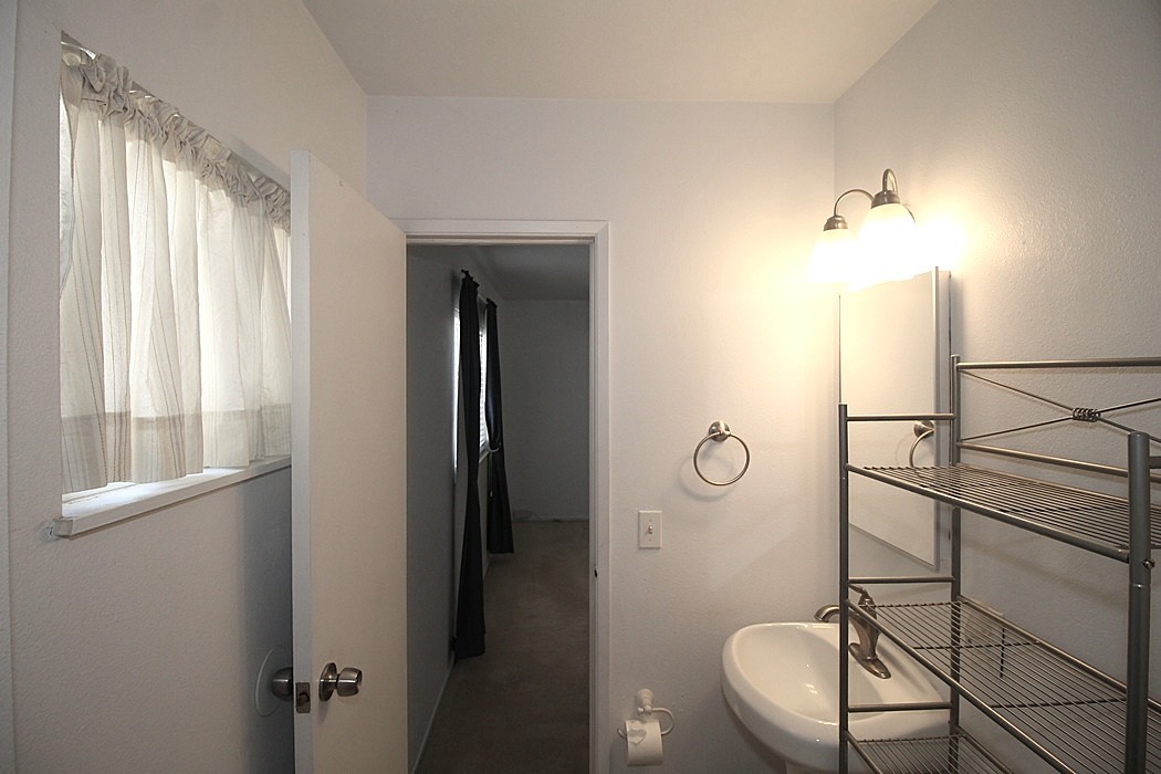 308 Muir Street Barstow, CA 92311 - Photo 21 of 27 a bathroom with a granite countertop sink a mirror and a shower