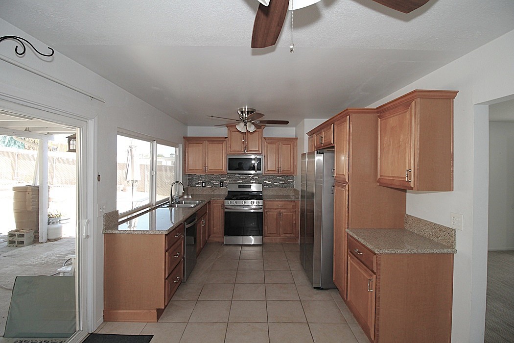 308 Muir Street Barstow, CA 92311 - Photo 7 of 27 a kitchen with stainless steel appliances granite countertop a refrigerator and a sink