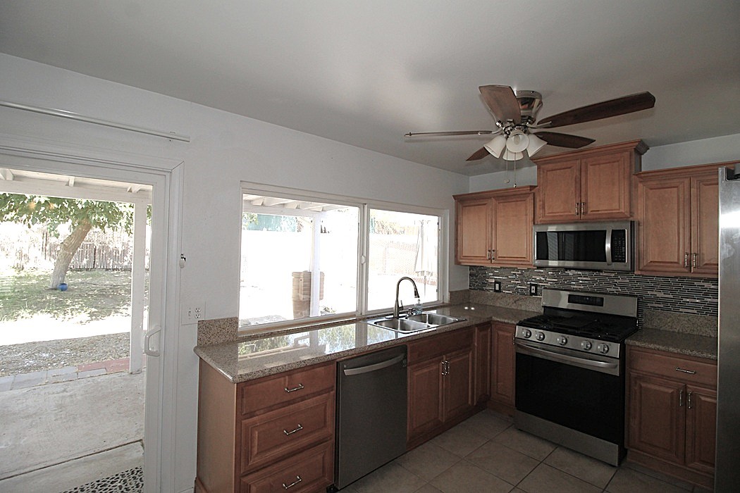 308 Muir Street Barstow, CA 92311 - Photo 8 of 27 a kitchen with stainless steel appliances granite countertop a stove and a sink