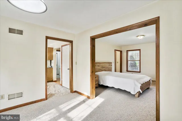 a spacious bedroom with a bed and a large window