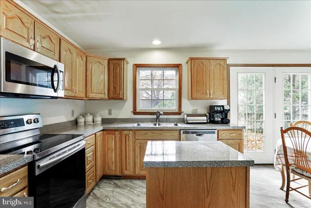 a kitchen with stainless steel appliances granite countertop a stove sink microwave and cabinets