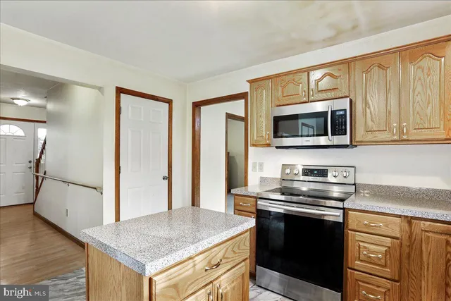 a kitchen with stainless steel appliances granite countertop a stove microwave and refrigerator