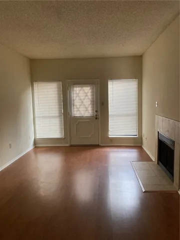 an empty room with windows and fireplace
