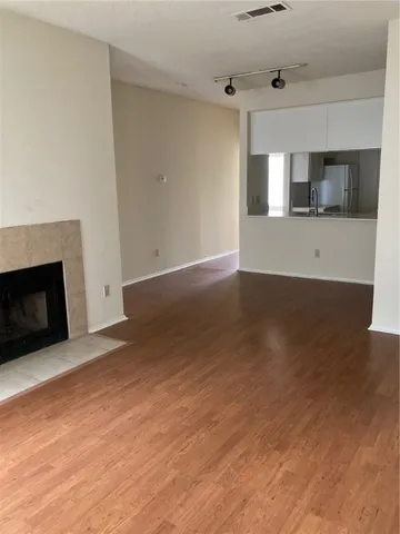 an empty room with wooden floor and fireplace