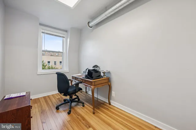 a view of a workspace with furniture and wooden floor