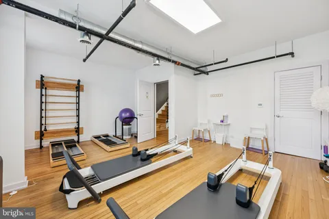 a room with gym equipment and wooden floor