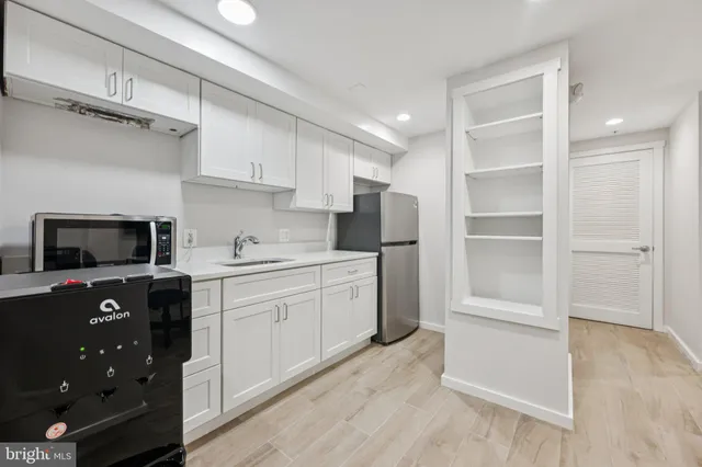 a kitchen with a refrigerator stove and white cabinets