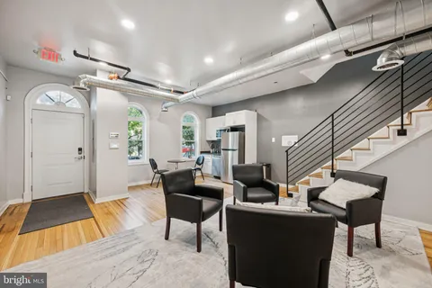 a living room with furniture and a wooden floor