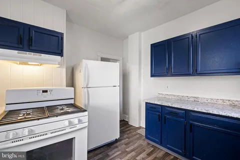 a kitchen with granite countertop cabinets stainless steel appliances and wooden floor
