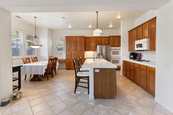 a large kitchen with a table and chairs