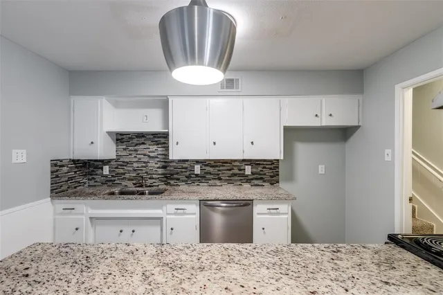 a kitchen with stainless steel appliances kitchen island granite countertop a stove a sink and a refrigerator