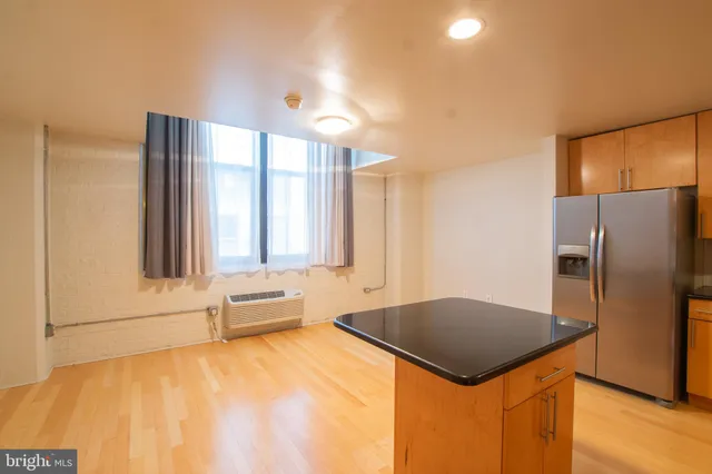 a kitchen with stainless steel appliances granite countertop a refrigerator a sink and a stove