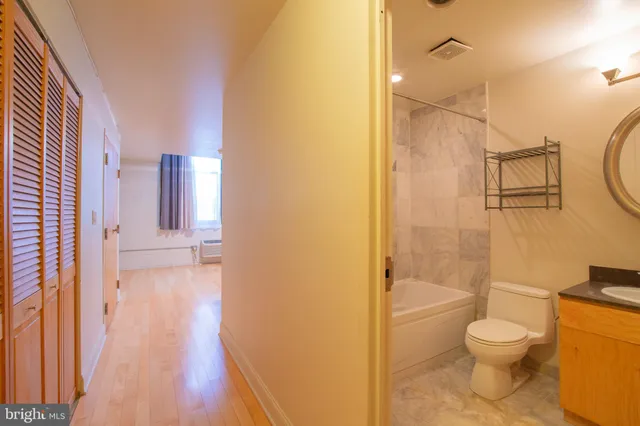 a bathroom with a granite countertop toilet a sink and shower