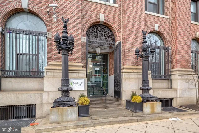 a front view of a house with large trees