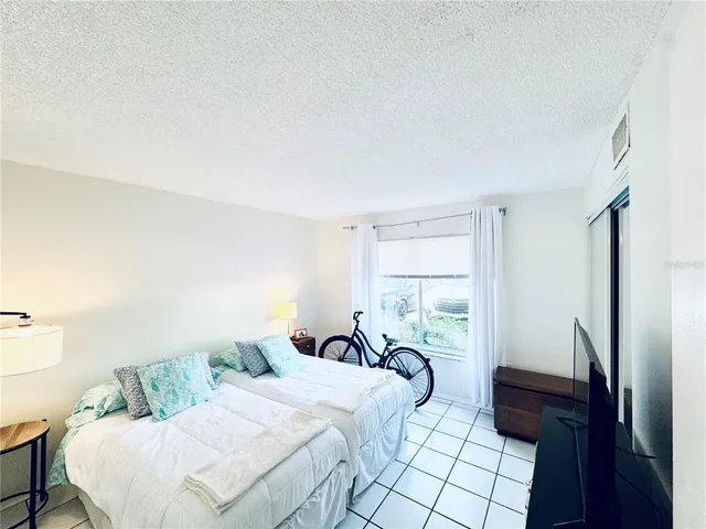 a view of a swimming pool with a yard and palm trees