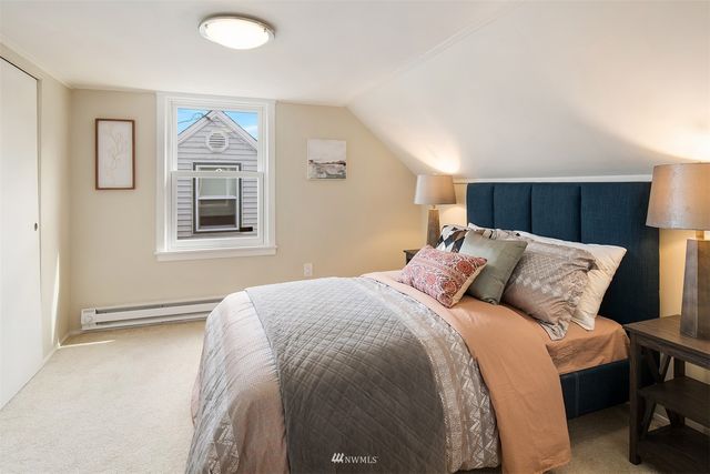 a bed room with a bed and a painting on the wall