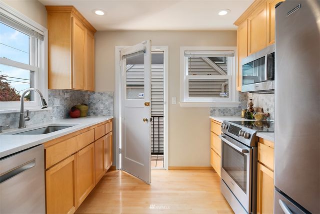 a kitchen with stainless steel appliances granite countertop a stove a sink and a refrigerator